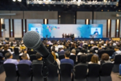 Microphone with Abstract blurred photo of conference hall or meeting room with attendee background, business and education concept